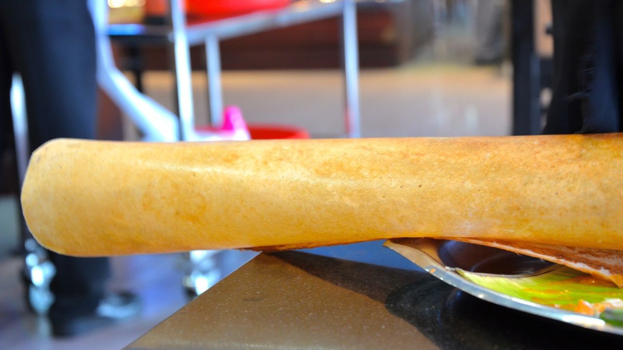 Paper Dosa: A paper dosa, or plain dosa, is a crispy South Indian food made with rice and lentil batter. This dosa is served with chutney and sambhar. You must try the paper dosa. (Picture credit: Living to Eat).