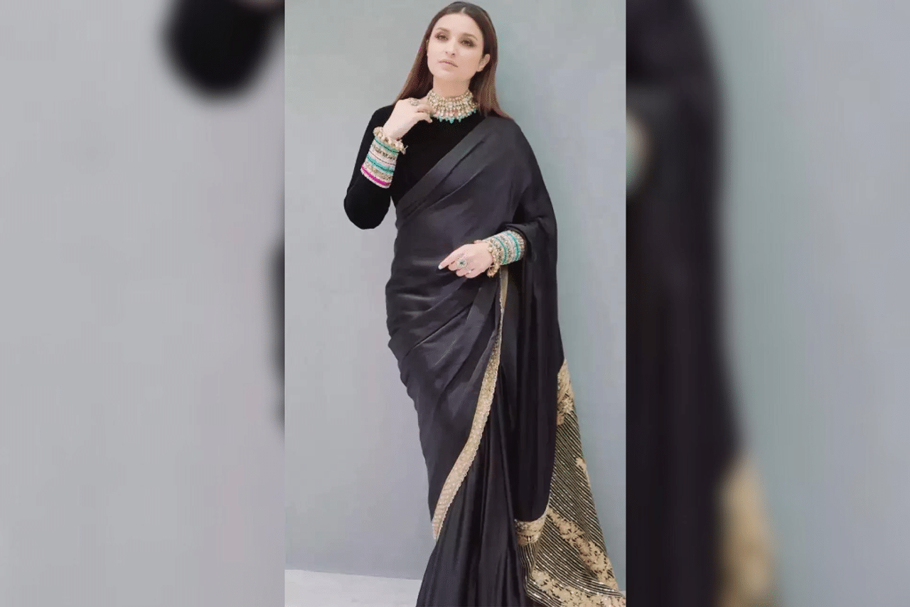 Back To Black: Parineeti recently donned an elegant black saree adorned with intricate gold borders. She beautifully complemented her attire with a velvet high-neck blouse that featured multihued embroidery and zari work around the cuffs. Her ensemble was further accentuated with the addition of ornate gold kadas, gold choker and a sleek hair do. (Photo Courtesy: @parineetichopra)