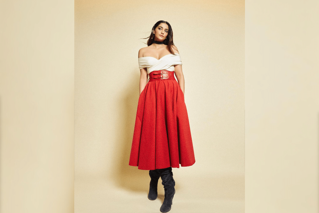 Princess Vibes: Sonam recently shared a picture of herself wearing a red and white off shoulder dress. The ensemble featured an alluring neckline and was accentuated by a broad leather belt that elegantly cinched her waist. Lastly she opted for tousled hair, knee-length boots, and a chic choker necklace to complete her outfit. (Photo Courtesy: @sonamkapoor)